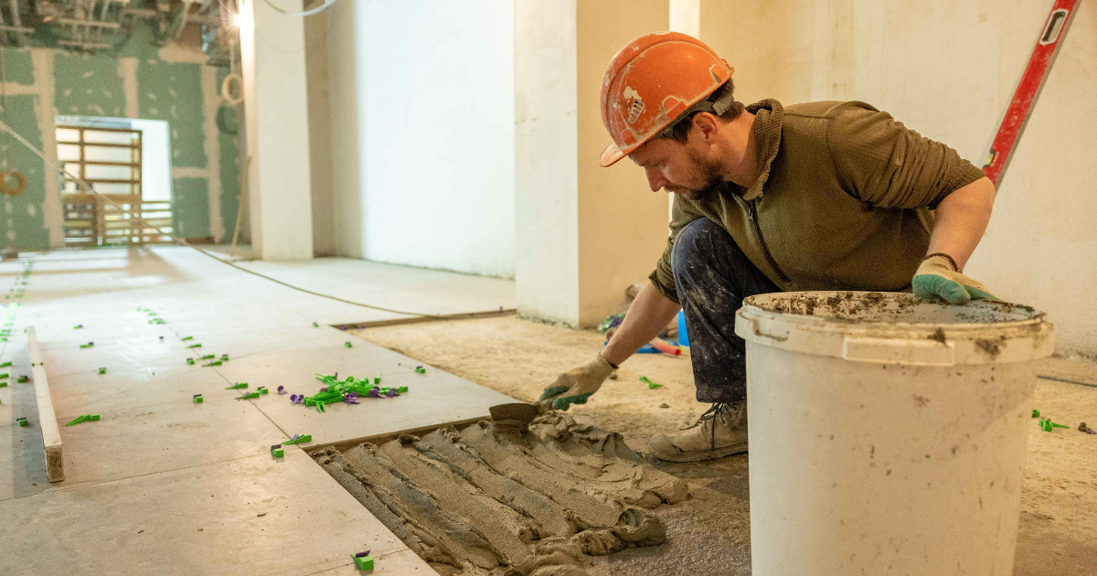 Commercial flooring installation in Las Vegas with tile being set by contractor